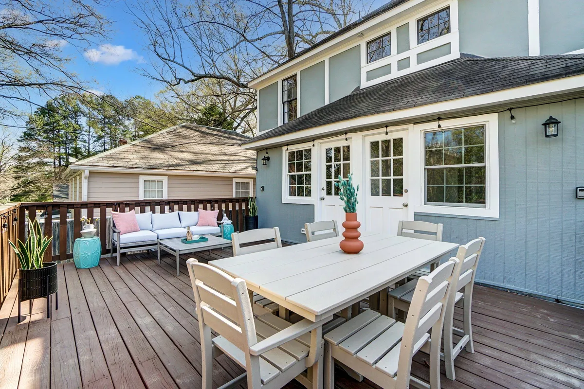 A cheerful outdoor dining and seating area adorned with decorative plants, perfect for relaxing after a day of city activities. The space is bright and open, inviting guests to unwind and gather with friends or family.